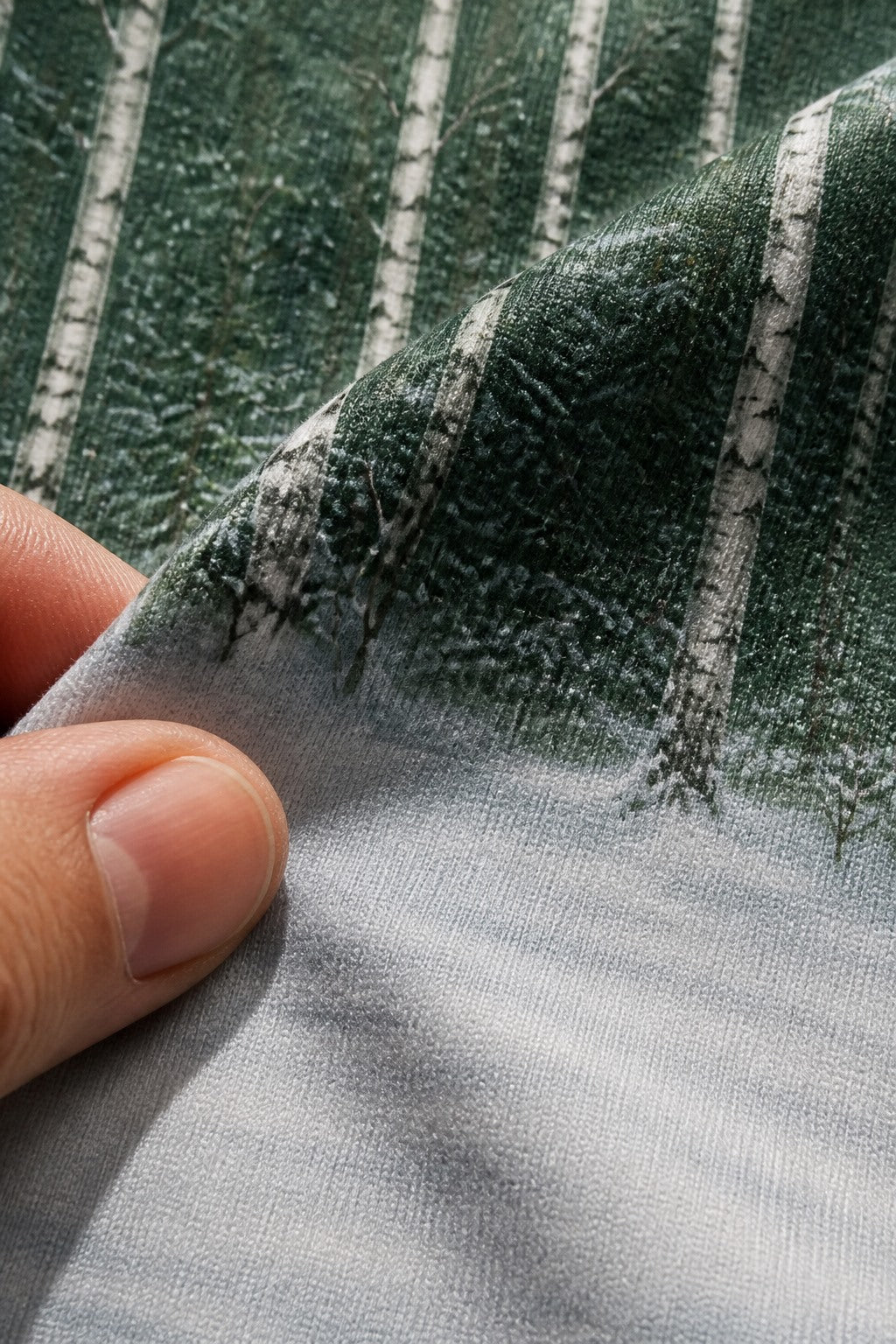 Close-up of the short-pile wrinkle-resistant fabric texture of the Winter Birch Forest photography backdrop, held at the corner